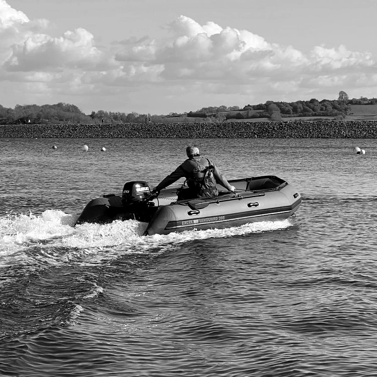The BPS rescue RHIB pulling away across a lake, its wake behind it, an operative at the tiller