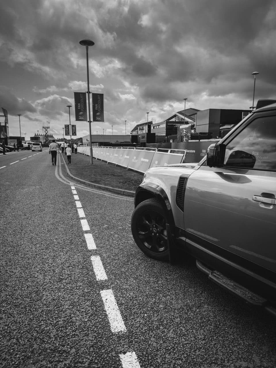A grey Defender parked beside the road at an event